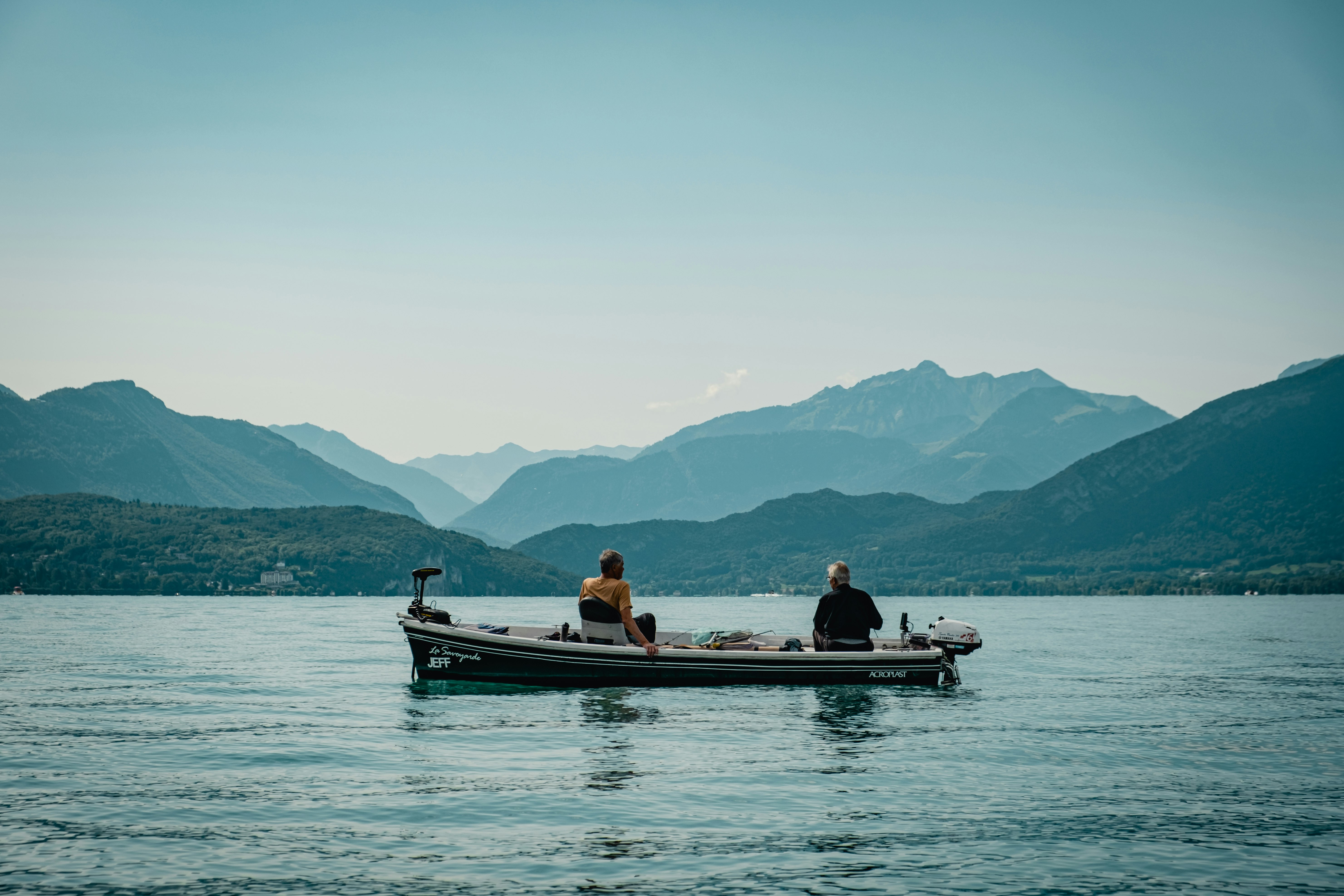 2 people riding on boat on sea during daytime